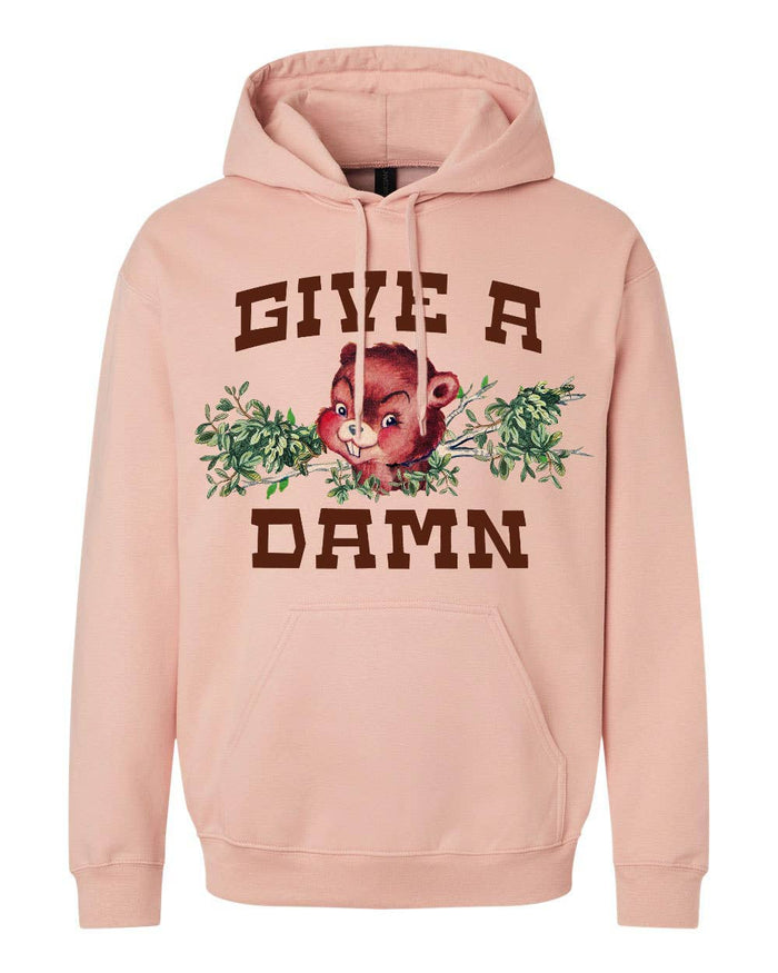 Pink Give a Damn hoodie by The Coin Laundry, soft fabric with bold text design, shown on a model.