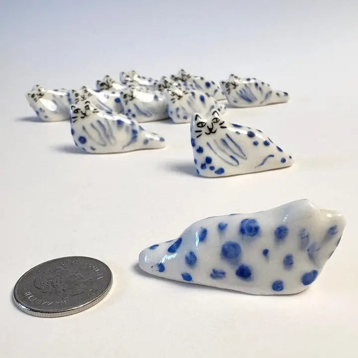 Blue leopard cat figurine beside a coin for size, white and dark blue dots