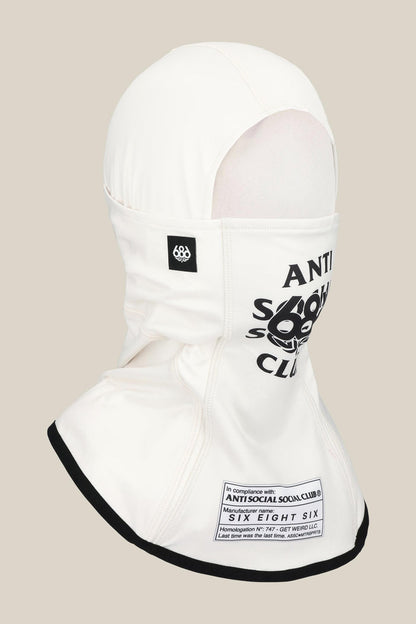 The 686 Alpha Hinged Balaclava by 686 is a white balaclava with black ‚ÄúANTI SOCIAL SOCIAL CLUB‚Äù text and logo on the front, a patch label near the bottom, and black trim around the lower hem.