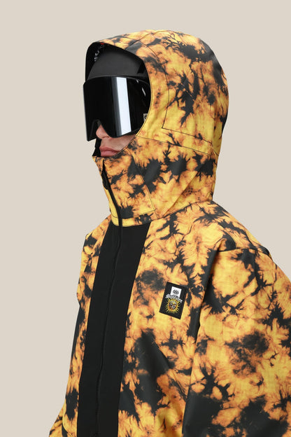 A man in the 686 Mens Sublime Shell Anorak (yellow and black) with the hood up, black ski goggles, and a face covering is photographed from the side against a plain beige background.