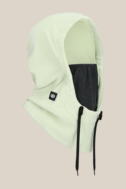 The 686 Tarmac Fleece Hood by 686 features a light green fleece, dark gray inner face covering, black drawstrings, and a small black logo tag‚Äîideal for pairing with winter gear‚Äîdisplayed on a plain beige background.