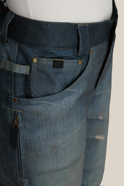 Close-up of the 686 Women's Deconstructed™ Denim Insulated Pant by 686, featuring front pockets, belt loops, brass rivets, and zipper details. The denim has a slightly worn texture and faded areas for a stylish, lived-in look.