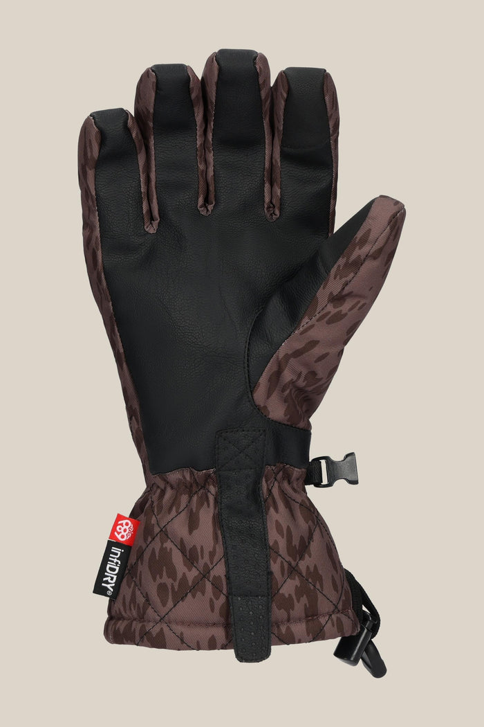 The 686 Women's Jubilee™ Glove by 686 features a brown and black patterned design, a black palm, adjustable wrist strap, and a side plastic buckle, displayed on a plain beige background.