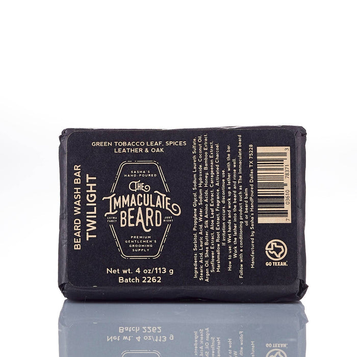 The Immaculate Beard Twilight Beard Oil bottle with a dark label, surrounded by natural ingredients like essential oils and herbs.