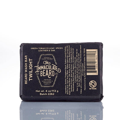 The Immaculate Beard Twilight Beard Oil bottle with a dark label, surrounded by natural ingredients like essential oils and herbs.