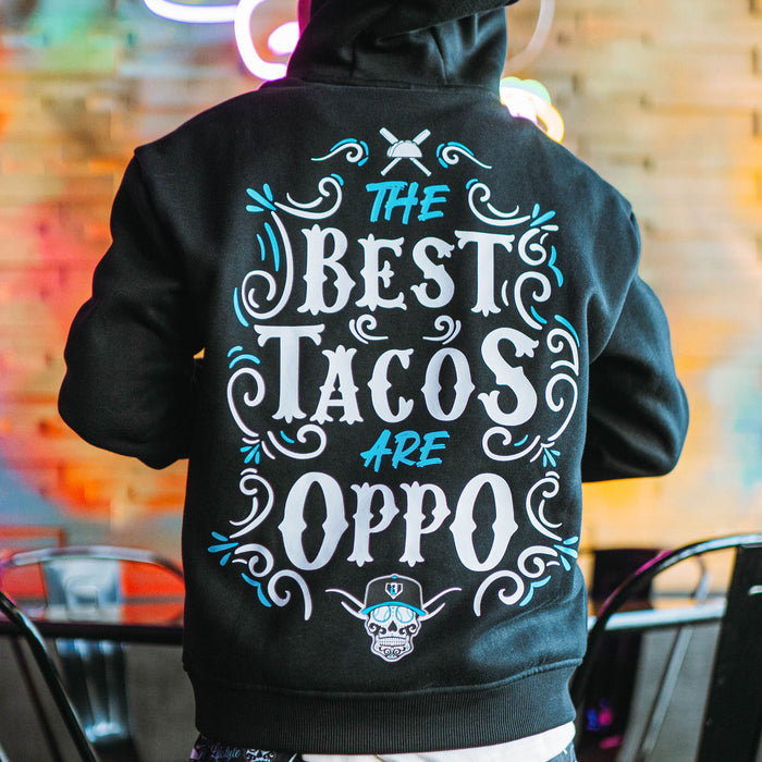 Person wearing black hoodie with 'The Best Tacos Are Oppo' text on the back