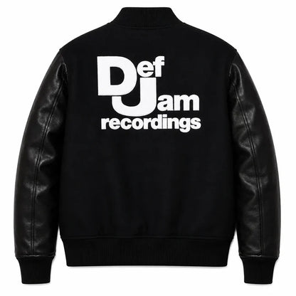 Front and back catalog layout of the Leveljacket Def Jam Recordings black varsity jacket, displaying a premium black wool body with black leather sleeves, custom white embroidered turntable needle art on the front chest, and a bold white Def Jam Recordings typography patch layout across the back.