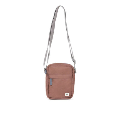 Brown canvas crossbody bag with zip top, small front pocket, and adjustable strap