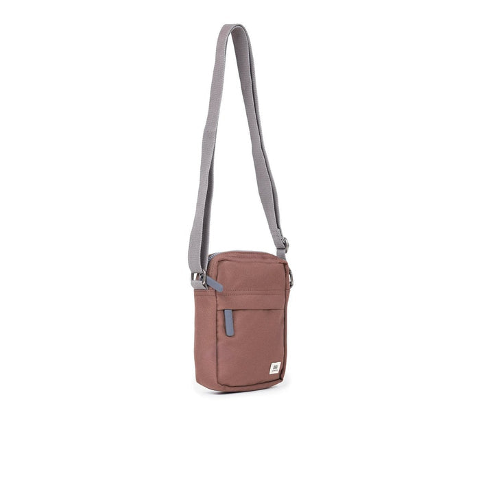 Dusty rose canvas crossbody bag with zip top, front pocket, and adjustable light strap