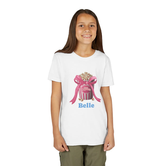 Smiling girl wearing white t-shirt with pink popcorn bucket and bow design and name Belle