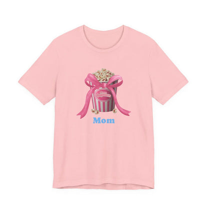 Pink t-shirt with popcorn bucket graphic tied with pink ribbon and blue Mom text