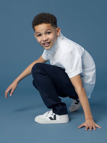 DL1961 boys' Brady Slim jeans in navy 'Dark Sapphire' on child model crouching, front view.