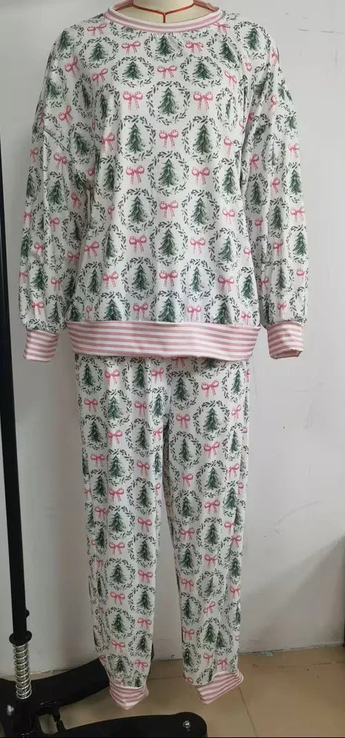Christmas-themed pajama set with trees and bows on a white background