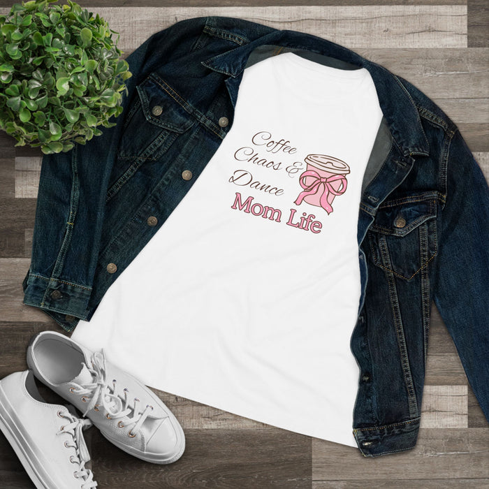 White t-shirt with 'Coffee, Chaos & Dance Mom Life' design on a denim jacket and wooden surface.