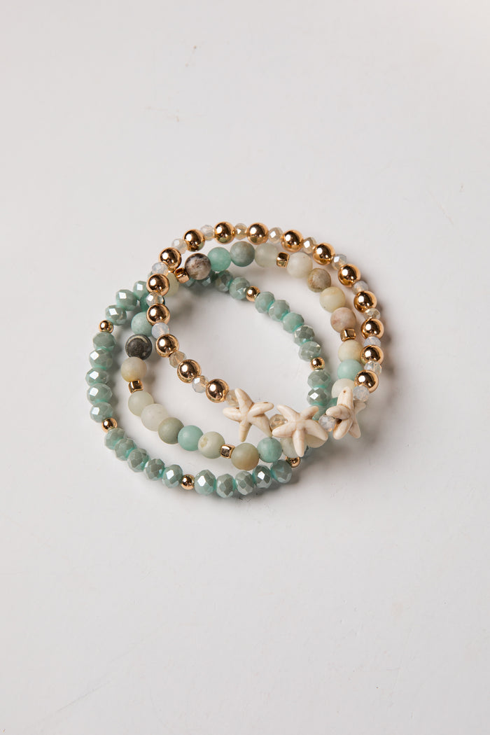 Set of beaded bracelets with starfish charm on a light background