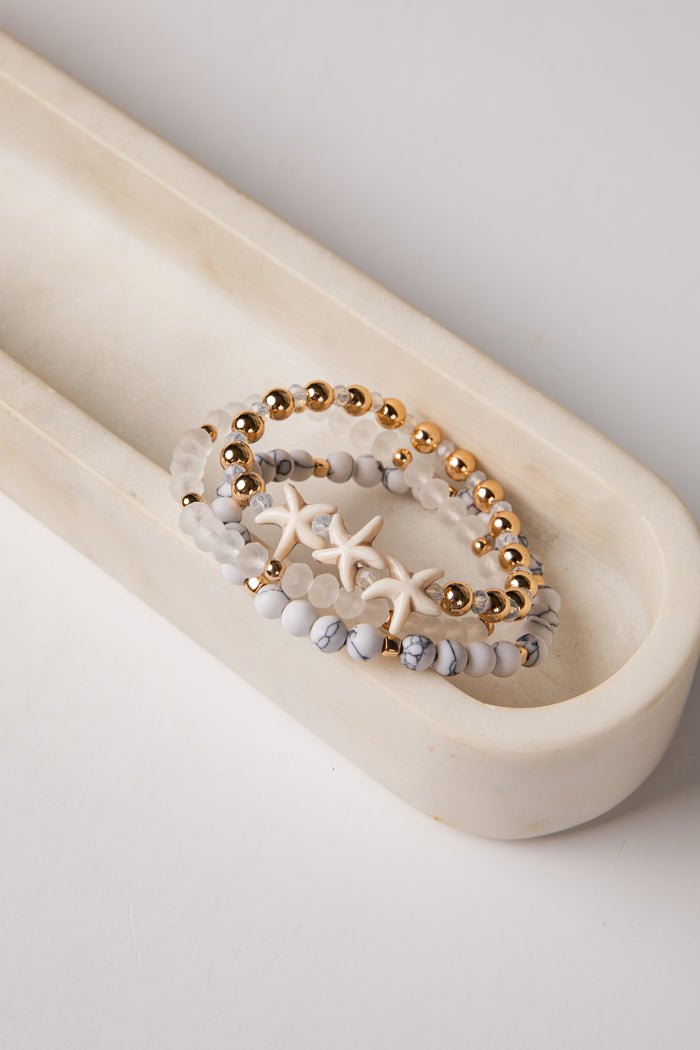 Beaded bracelet with starfish design on a white dish