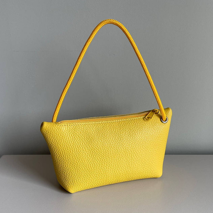 Yellow cord pouch with matching braided handle and smooth leather texture.