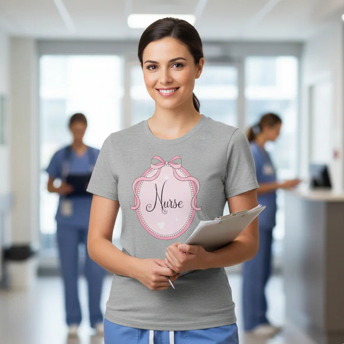 Woman in a hospital setting wearing a 'Nurse' t-shirt with a pink design.