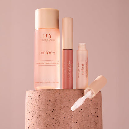 Tall pink bottles from the Daily Essentials Set displayed against a soft pink background