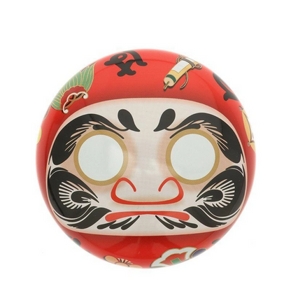 Red Daruma doll tea canister with black and white face design on a white background