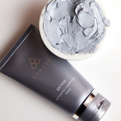 Close up of charcoal chunks and a Detox Activated Charcoal Mask tube on a plate