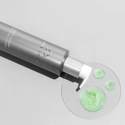 Cleanser tube with green gel on a light gray background