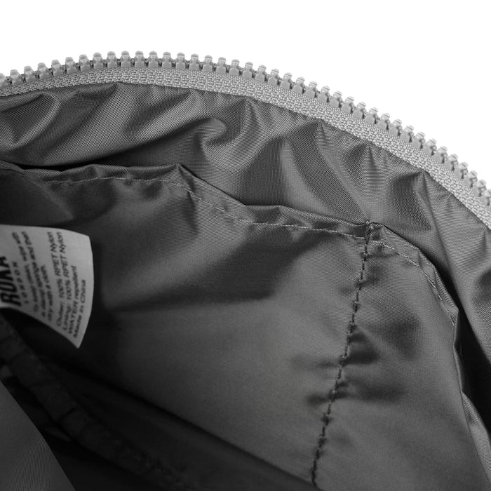 Half-moon bag interior lining with visible stitching and zip closure at top edge.