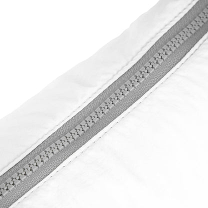 Coconut half-moon bag zip seam detail with gray zipper track and white fabric.