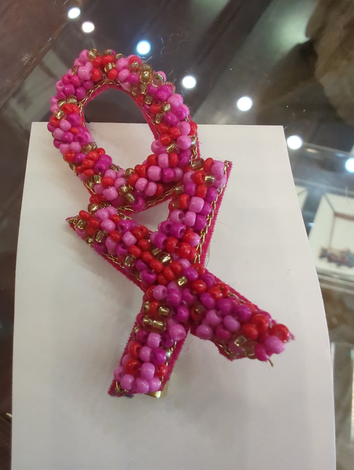 Colorful beaded pins from Camel Threads featuring vibrant, handcrafted designs on a pin backing.