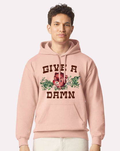 Pink "Give a Damn" hoodie by The Coin Laundry, front view showing the hoodie with bold text design and soft fabric texture.