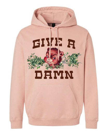 Pink Give a Damn hoodie by The Coin Laundry, soft fabric with bold text design, shown on a model.