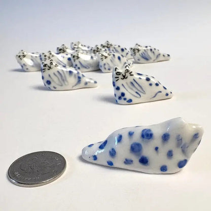 Blue leopard cat figurine beside a coin for size, white and dark blue dots