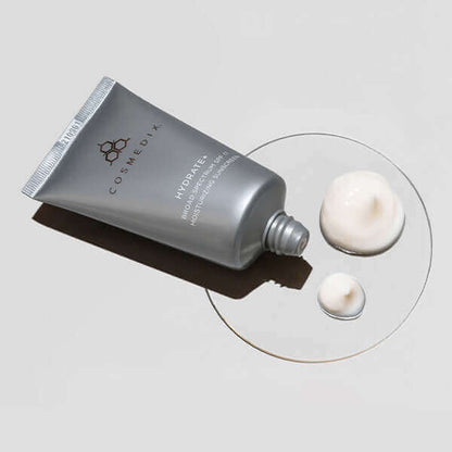 Hydrate+ SPF Moisturizing Sunscreen tube with cream swatches on a pale surface