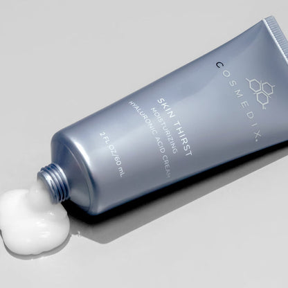 Cosmedix Skin Thirst cream tube with a small amount of cream on a gray background