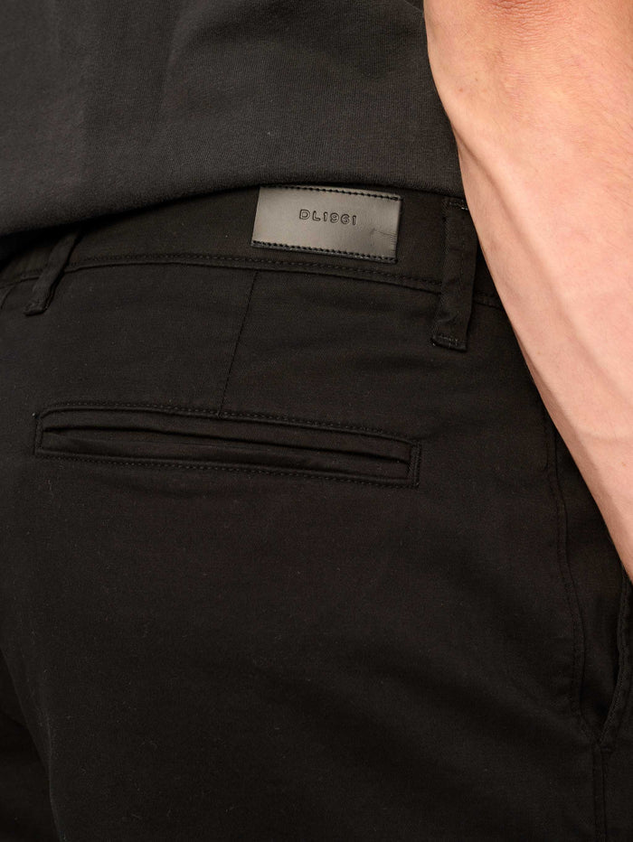 DL1961 men's Jake chino short in black, detail of back welt pocket and logo label.
