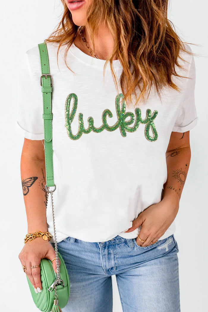 Person wearing a white t-shirt with 'lucky' text, holding a green bag on a white background