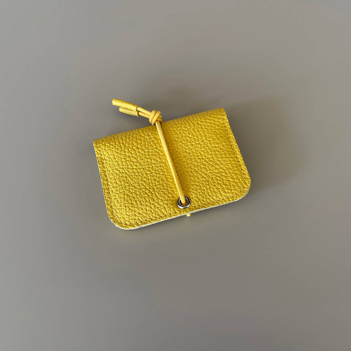 Yellow leather mini wallet with knot closure and metal eyelet button