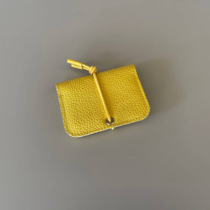 Yellow leather mini wallet with knot closure and metal eyelet button