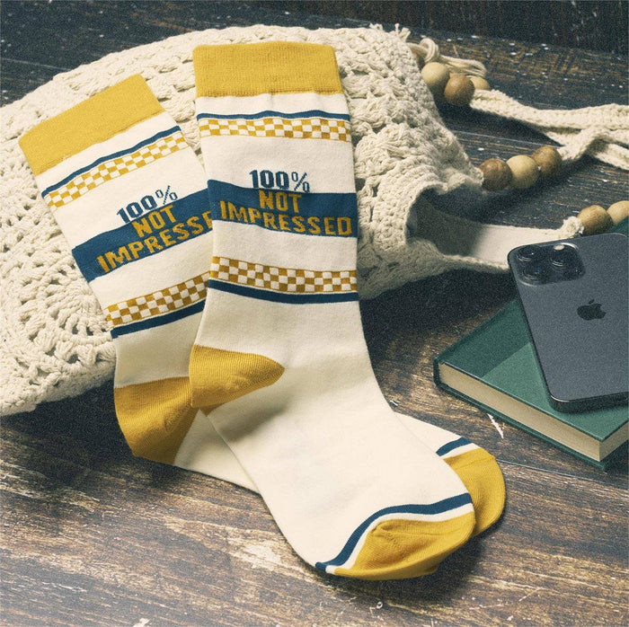 Questionables Not Impressed Socks featuring a humorous face design on black fabric, casual and comfortable for everyday wear