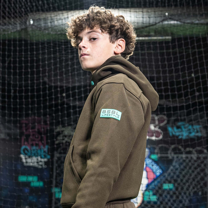 Person wearing a brown hoodie with a BL101 logo in front of a colorful, abstract background
