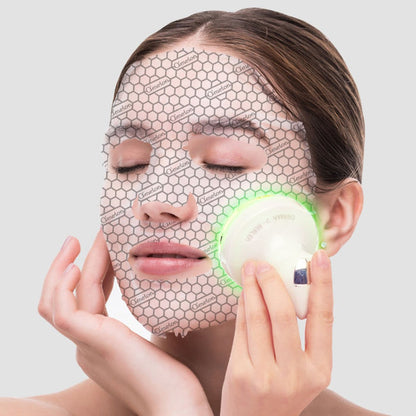 Model wearing an O’Melon sheet mask while using the Derma V-Healer device with green LED light for post-treatment calming care.