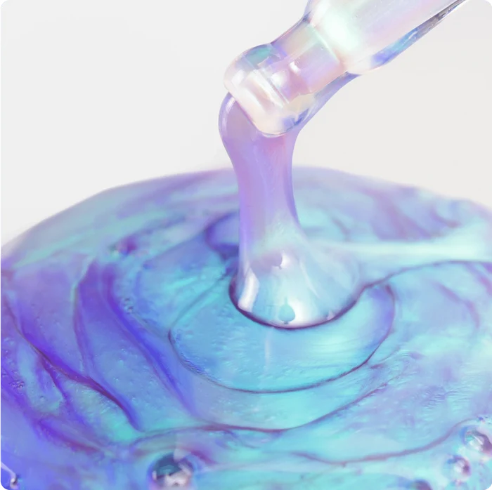 Iridescent liquid being poured onto a surface with a white background