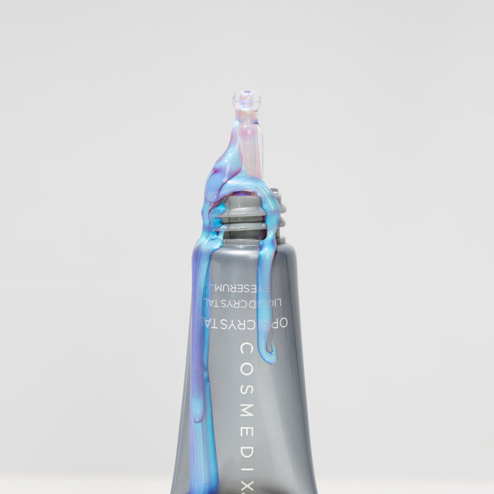 Cosmedix skincare product with iridescent cap on a light gray background