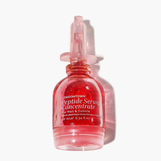 LONDONTOWN Peptide Serum Concentrate is a small bottle with pink liquid and a clear dropper, ideal for nourishing nail and cuticle care.