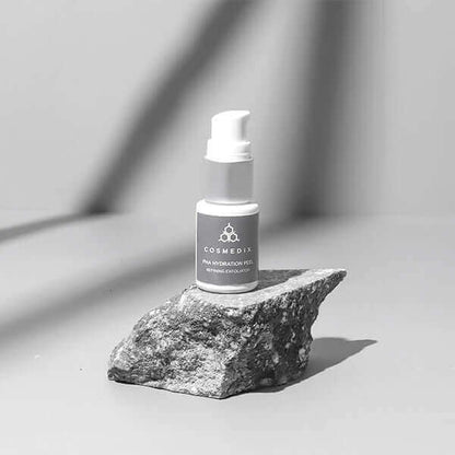PHA Hydration Peel bottle with pump on a rock captured in monochrome