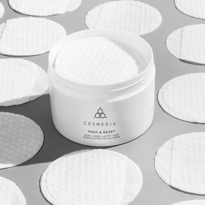 CosMedix Prep & Reset dual-sided lactic acid exfoliating facial pads in a white jar surrounded by pads.