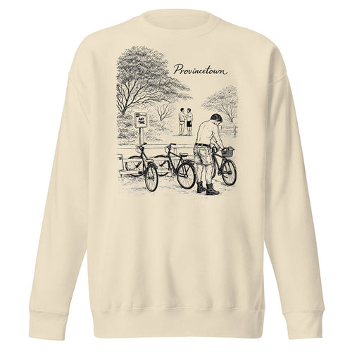 A cream-colored crewneck sweatshirt featuring a black line art graphic of a person with bicycles in a park, with the word 'Provincetown' printed above the illustration.