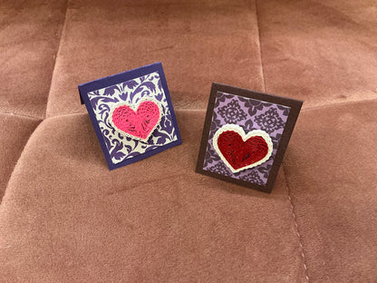 Colorful quilled heart pin from Cat's Quilling featuring intricate paper quilling artwork on a pin backing.