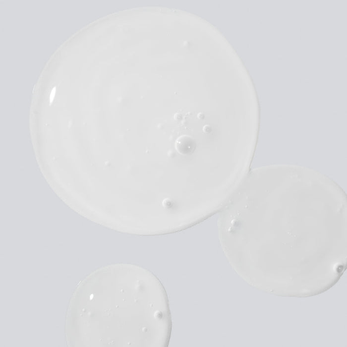 Close-up of Reboot Overnight Hydration Complex serum texture with bubbles on a pale surface