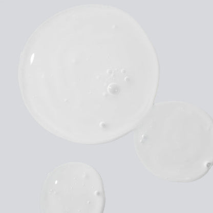 Close-up of Reboot Overnight Hydration Complex serum texture with bubbles on a pale surface